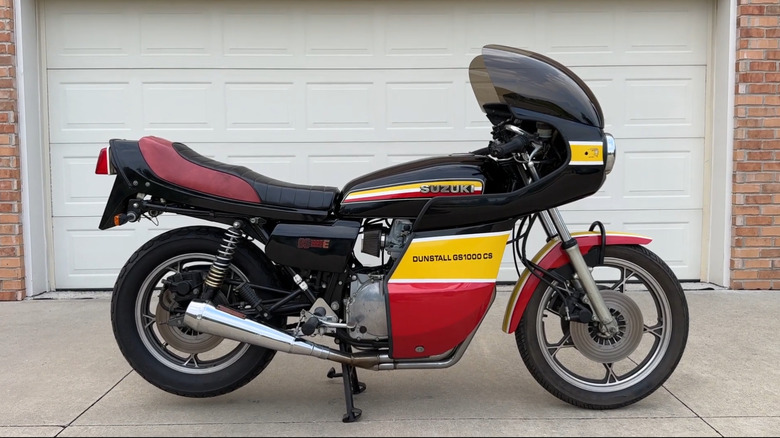 Suzuki Dunstall GS1000CS in race-inspired black, yellow, and red livery, featuring full fairing and cafe racer styling.