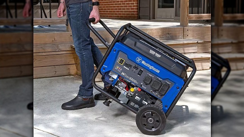 Man transporting a portable WestingHouse generator.