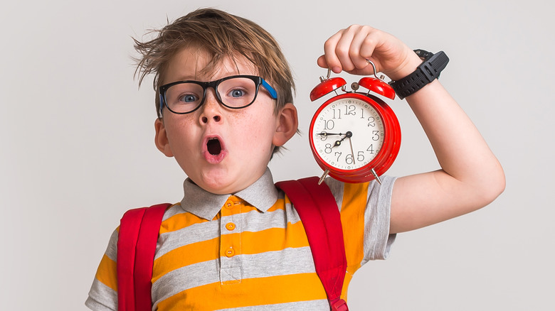 child holding alarm clock