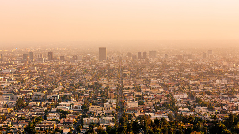 A sprawling city slightly obfuscated by an orange fog.