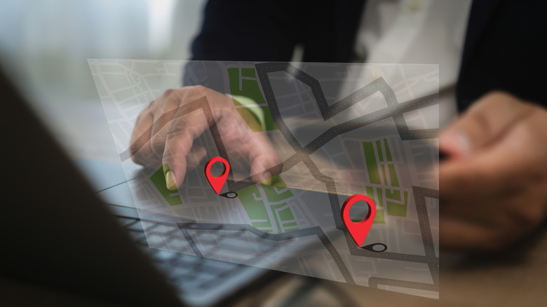 A person navigates uses a PC, a digital map is overlayed on the picture.