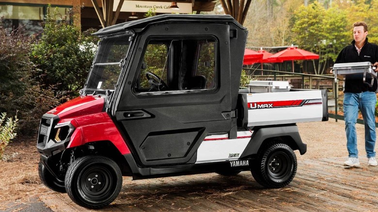Man loading the Yamaha UMAX Two golf cart.