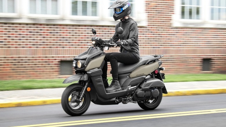 Person riding Zuma 125 on a road.