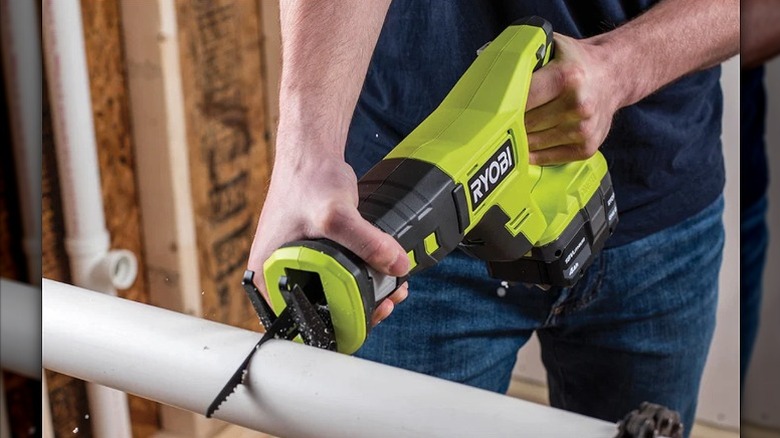 Cutting a pipe with a Ryobi saw.