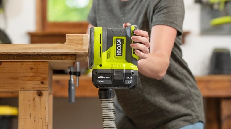 Using random orbit sander to smooth wooden edges.
