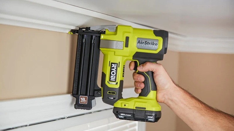 Using a brad nailer near the ceiling.