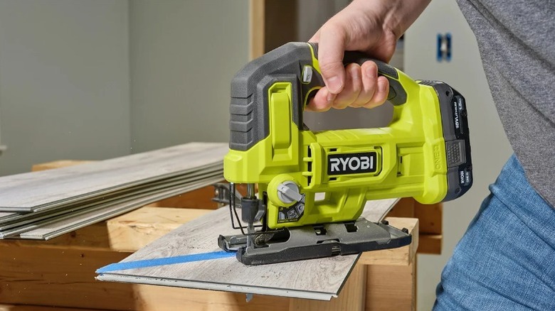 Using jig saw to cut pieces of drywood.