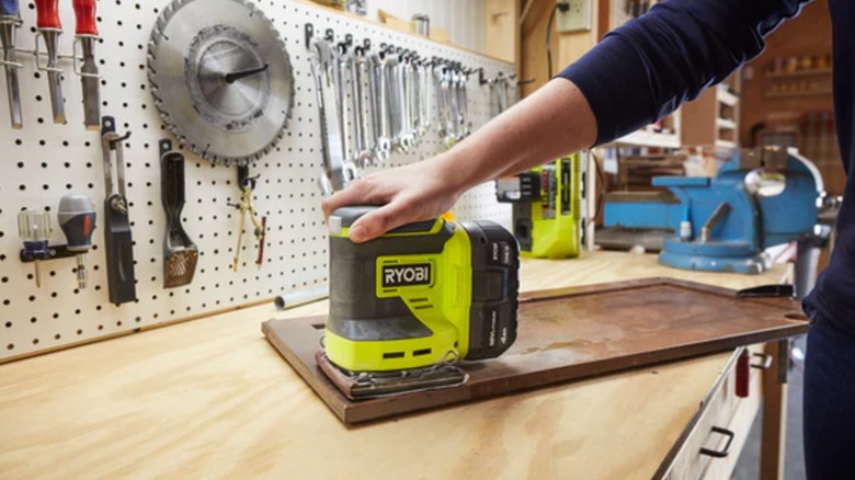 DIYer sanding cabinet door with Ryobi sheet sander