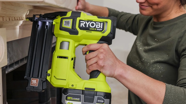 DIYer installing trim pieces with Ryobi brad nailer