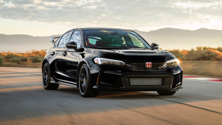 A black 2026 Honda Civic, finished here in the Type R Hatchback version, moving down a straight road at speed.