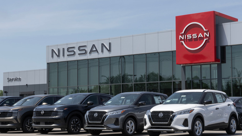 A row of differently-colored subcompact Nissan SUVs including two Nissan Kicks on display outside a dealership for Nissan.