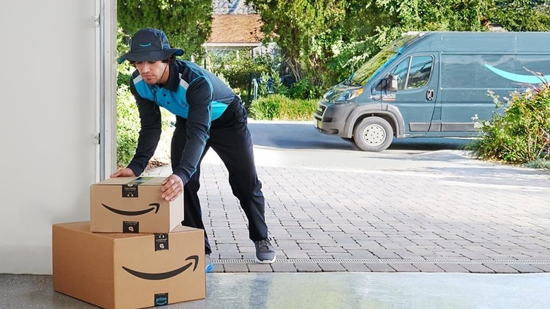 Amazon delivery person stacking boxes in a home garage