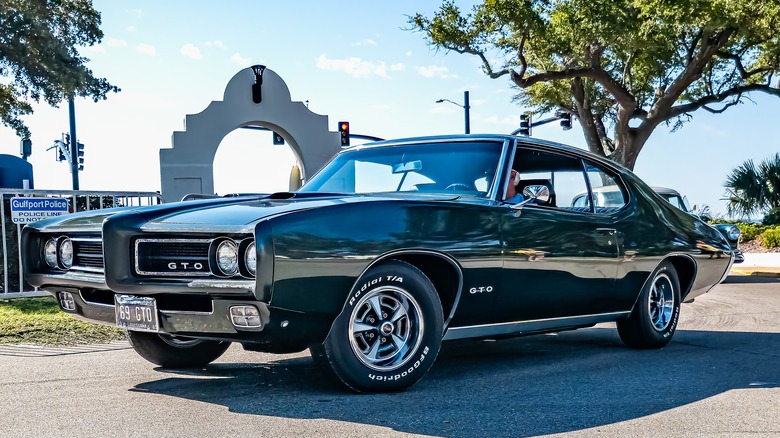 A black 1969 Pontiac GTO American muscle car at a local car show