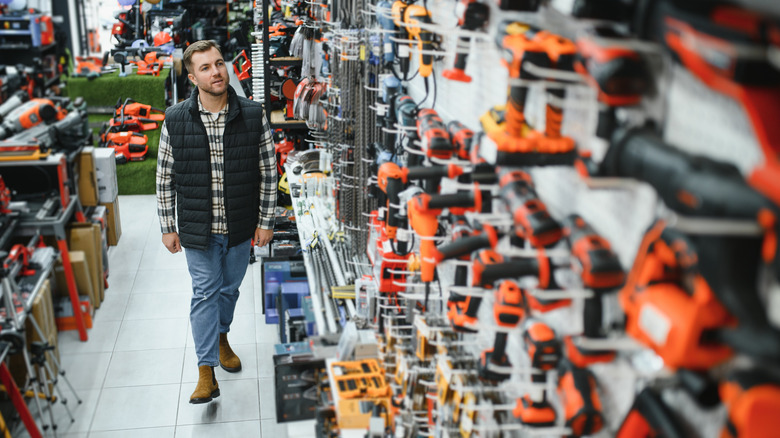 man walking down a power tool aisle in store