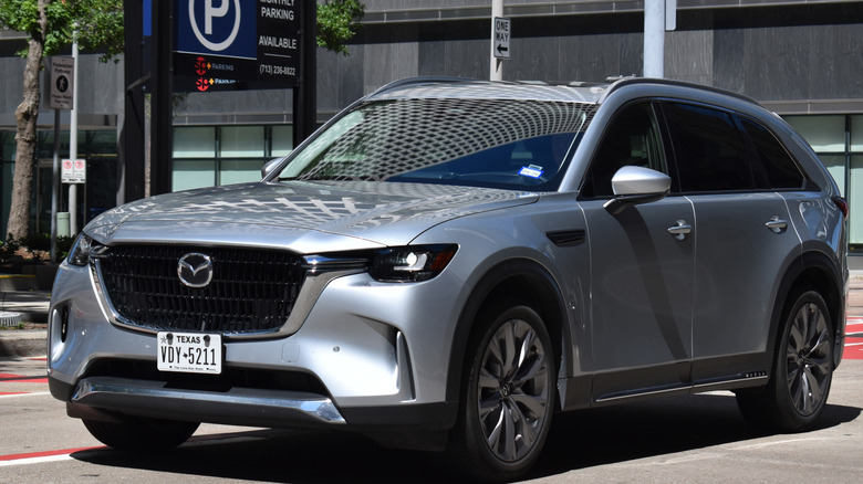 Mazda CX-90 in front of a parking sign