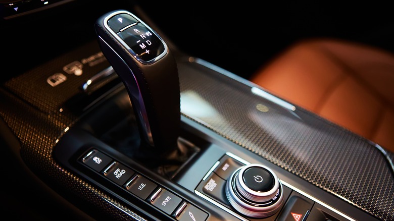 A modern car's center console, featuring a sleek gear shift knob 