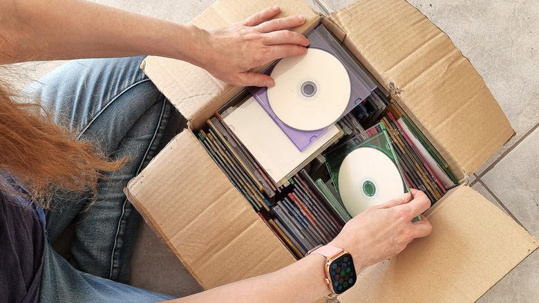 A person inspecting a box of discs
