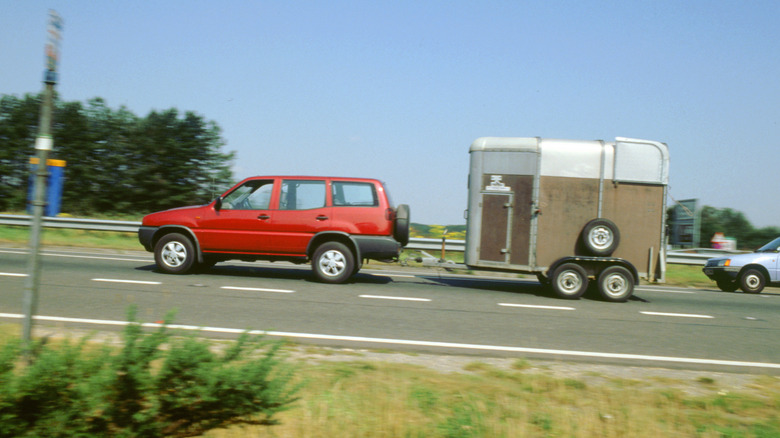 a small SUV towing a medium-sized trailer box