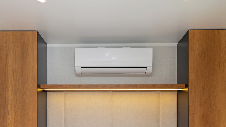 Mini split air conditioner on a wall with cabinets on either side