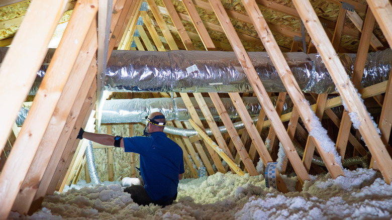 Person in an attic with insulation