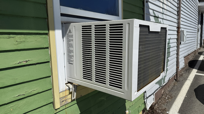 Window AC unit on the exterior of a green wall