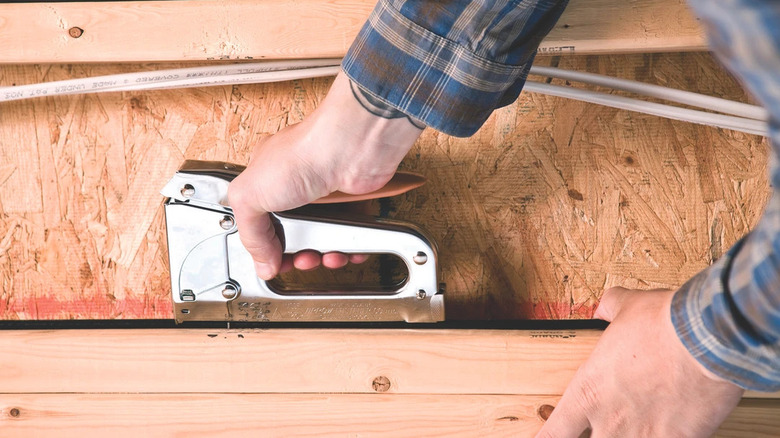 The Arrow T25 Low Voltage Wire Staple Gun being used on wood