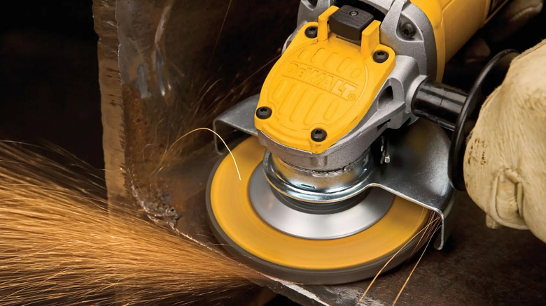 The DeWalt Small Angle Grinder with Paddle Switch being used on metal