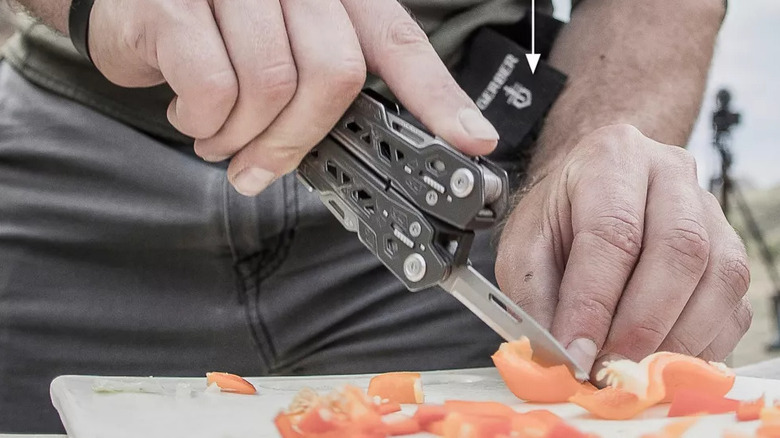 Closeup of a person's hand cutting a pepper with the Gerber multi-tool knife