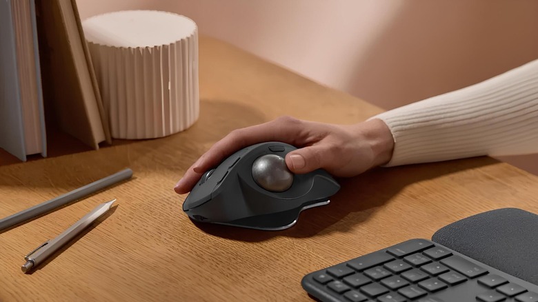 A person using a Logitech trackball mouse