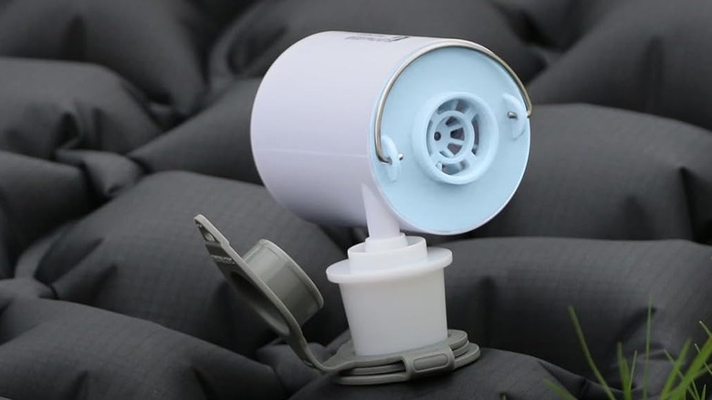Closeup of Flextailgear air pump inflating a sleeping pad with small images showing other items it can be used with, including an air pillow, vacuum bag, sleep pad, and pool float