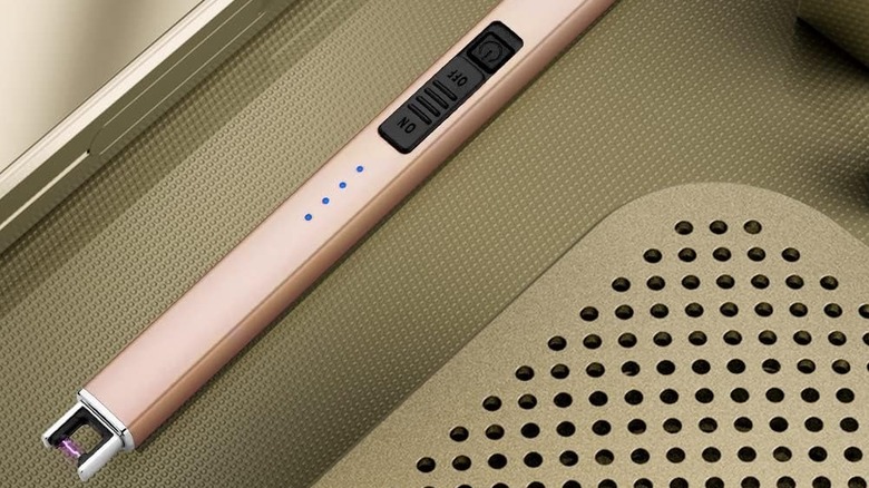 Cropped closeup of a pink Suprus electric lighter on a surface