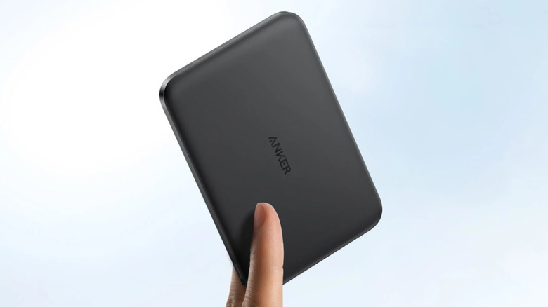 The Anker Nano Magnetic Power Bank held with two fingers on a bluish-white background