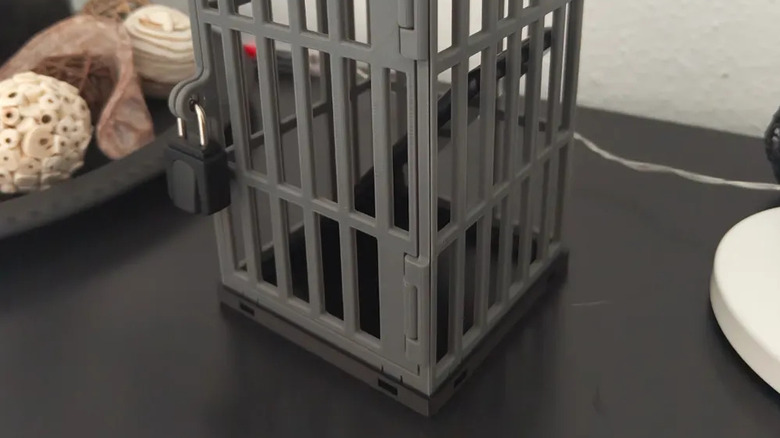 A phone jail sitting on a table with an imprisoned phone