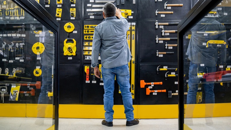 A man shopping for tools viewed from behind