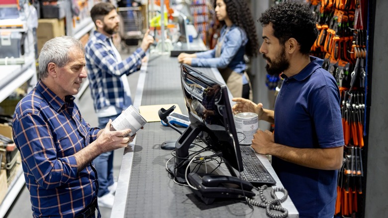 A man talking to a cashier at a hardware store