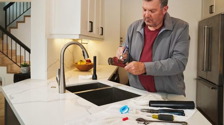 Person spraying WD-40 on stubborn hand tools