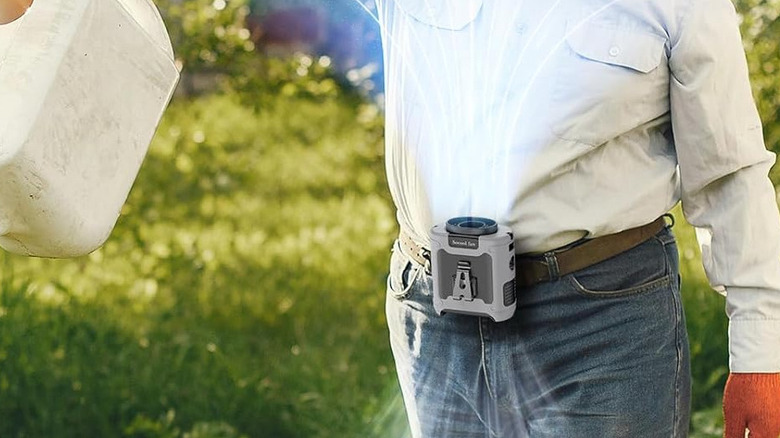 A person using the Socool portable fan clipped onto their waist