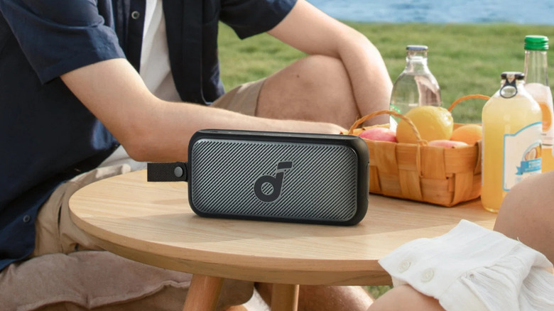 The Anker Soundcore Motion 300 speaker placed on a table with two people around it