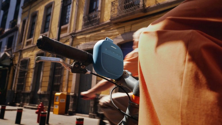 The Bose SoundLink Micro (2nd Gen) speaker attached to the handle of a bicycle
