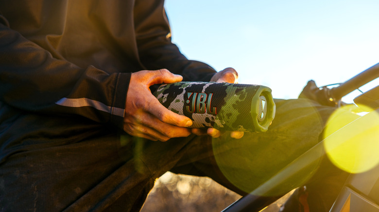 A person holding the JBL Flip 7 with a camo design in their hands