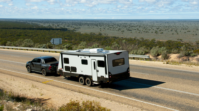 Truck pulling a camper on a highway