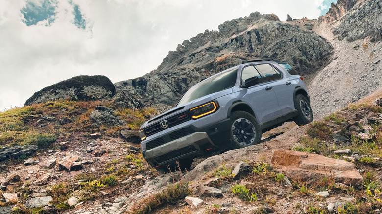 A blue Honda Pilot navigating rough terrain