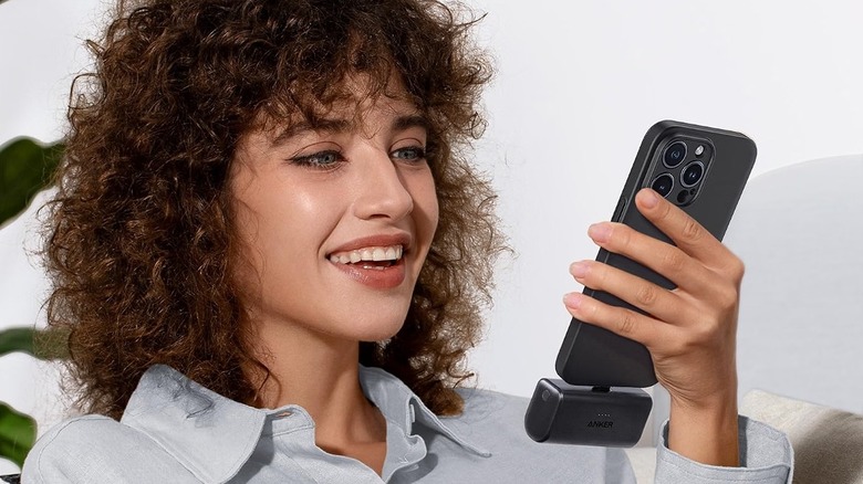 A person holding an iPhone with the Anker Nano 5,000mAh power bank plugged into it