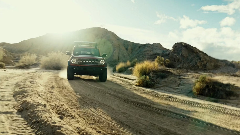 A Ford Bronco driving along a hill trail.