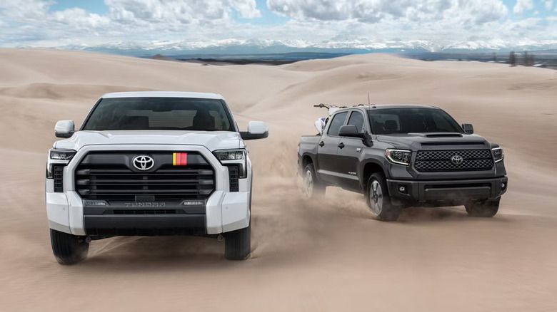Two Toyota trucks driving through a desert.