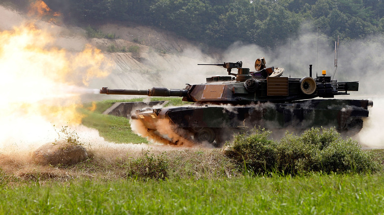 An M1A2 Abrams tank firing live rounds in a field