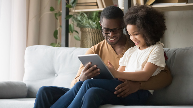 Father and child using iPad