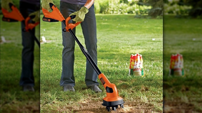 Using a garden cultivator in a patch of soil in the garden.