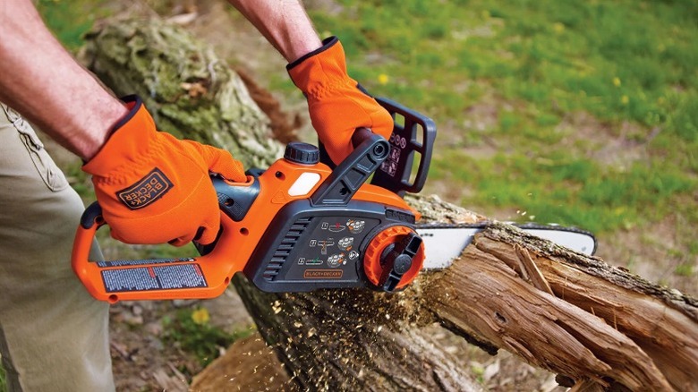 Using a chainsaw to cut a piece of wood.
