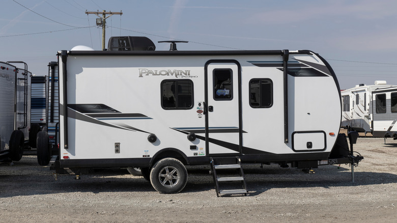 A Palomini camper 5th-wheel van sitting in a lot waiting to be hitched